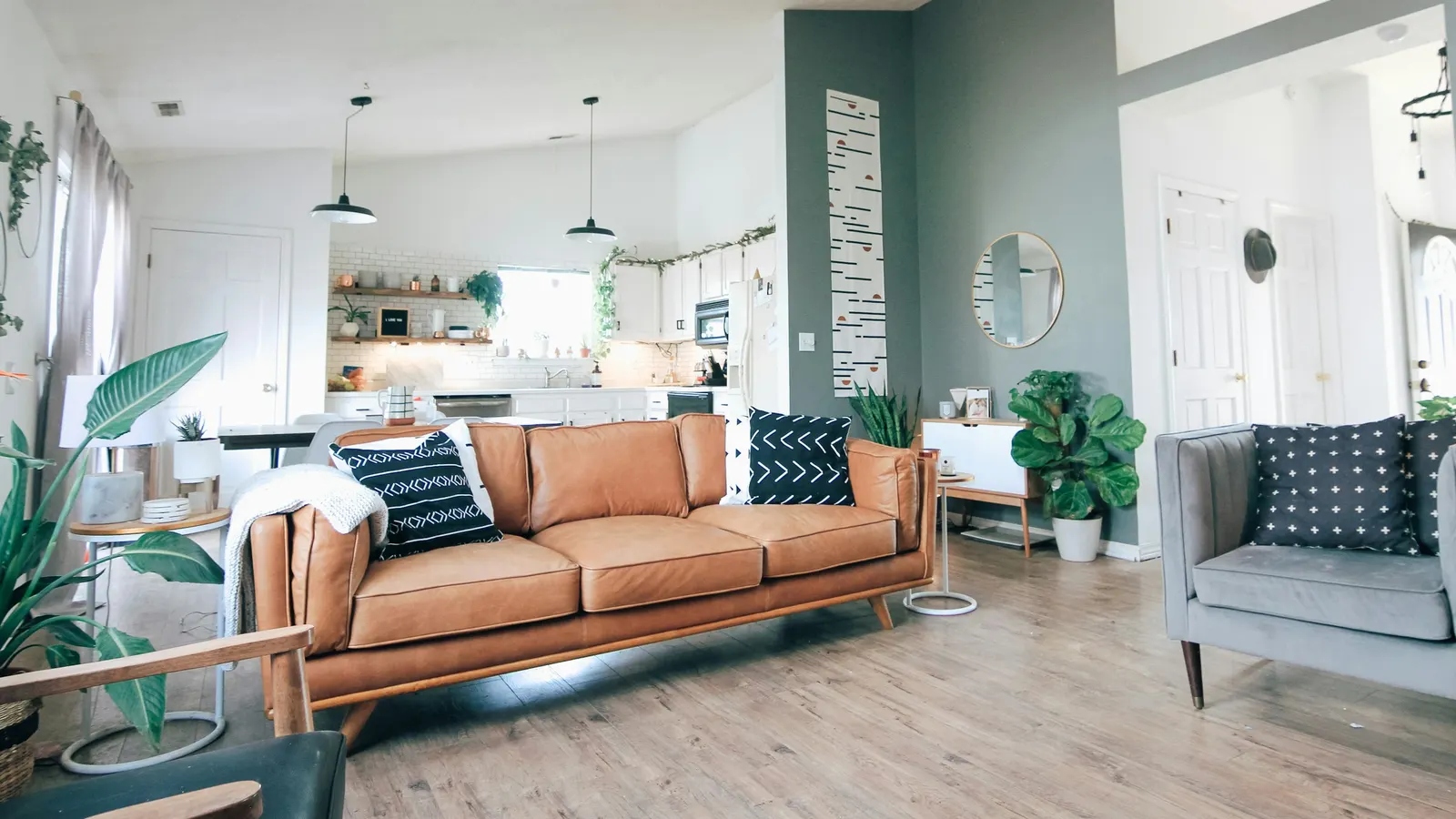 Clean, bright living room with a sofa and open kitchen